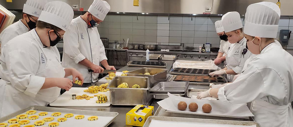 DMACC culinary students preparing a meal at the Iowa Culinary Institute