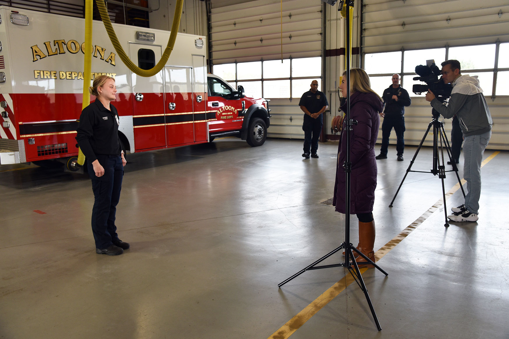 With her colleagues cheering her on, DMACC alum and current Altoona Fire Department fire medic Emma Kolb (above, left) talks with KCCI-TV reporter Laura Terrell (center) about how she stayed calm while helping deliver a baby on the side of a major road. 