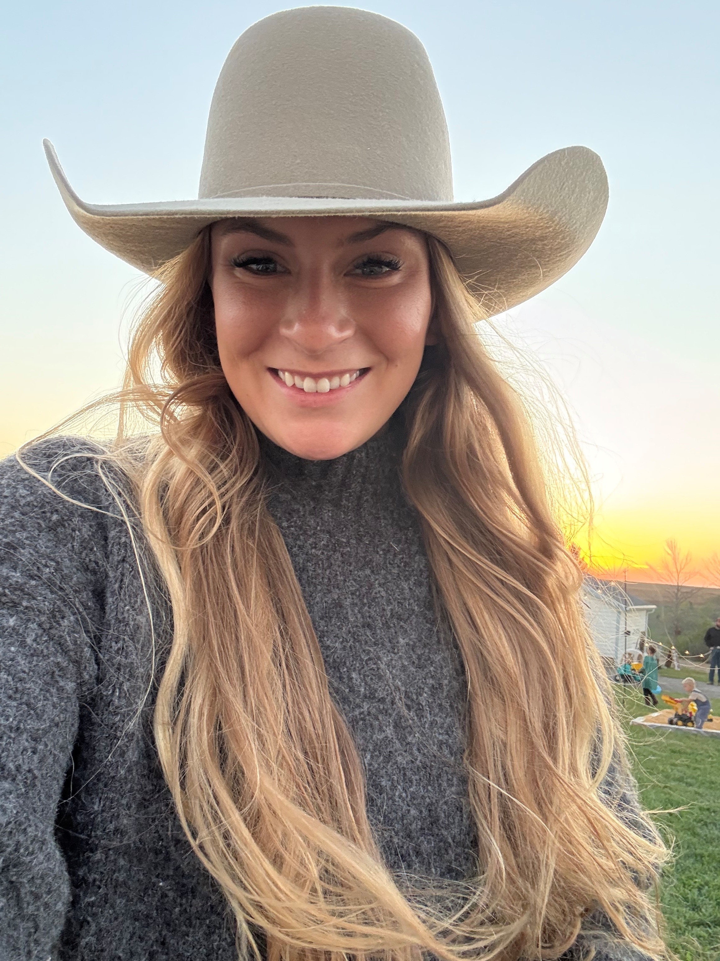 Selfie of woman with long blonde hair wearing tan cowboy hat