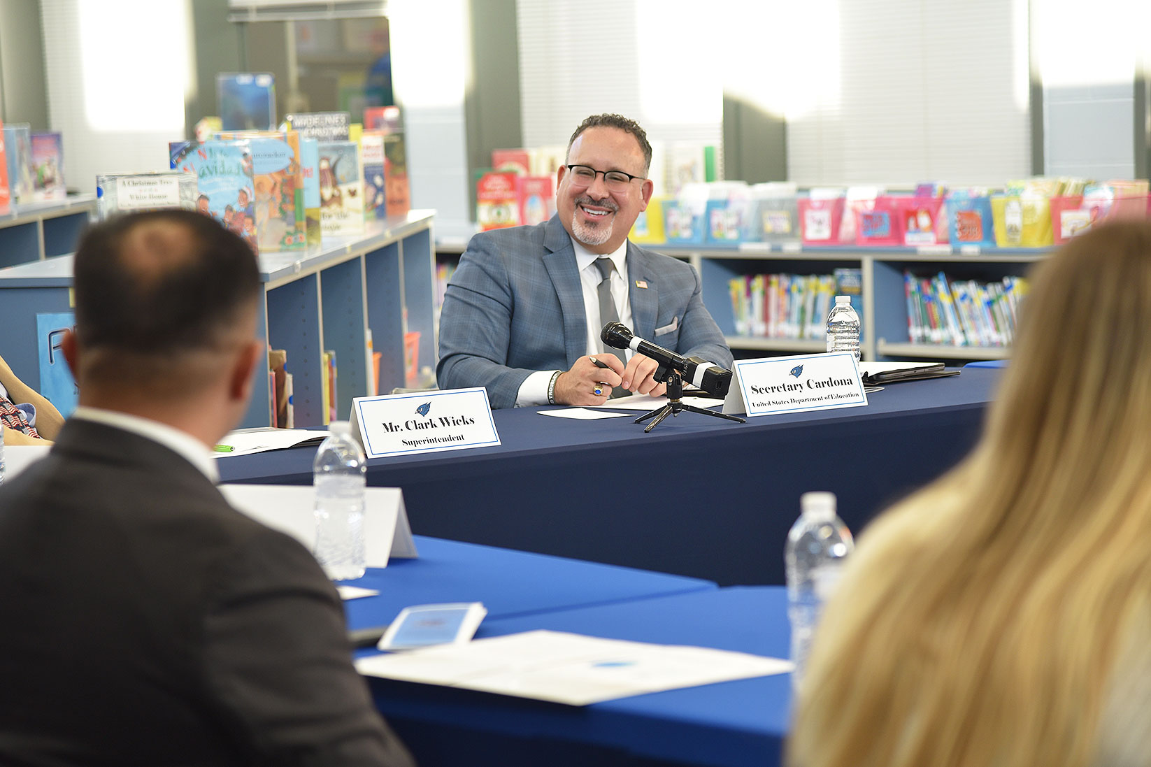 U.S. Secretary of Education Dr. Miguel Cardona (center) shares a light moment with Eddie Diaz, DMACC Perry VanKirk Center Director (left, back to camera), and Callie Steva, Perry High School Student-Teacher Prep Program participant (right, back to camera), during a Dec. 7, 2023, roundtable discussion at Perry Elementary School.   Dr. Cardona began his career as a fourth-grade teacher in Connecticut and went on to become an elementary school principal. He said Perry Elementary’s recognition as a 2023 National Blue Ribbon School is an accomplishment the entire community should be proud of and celebrate.