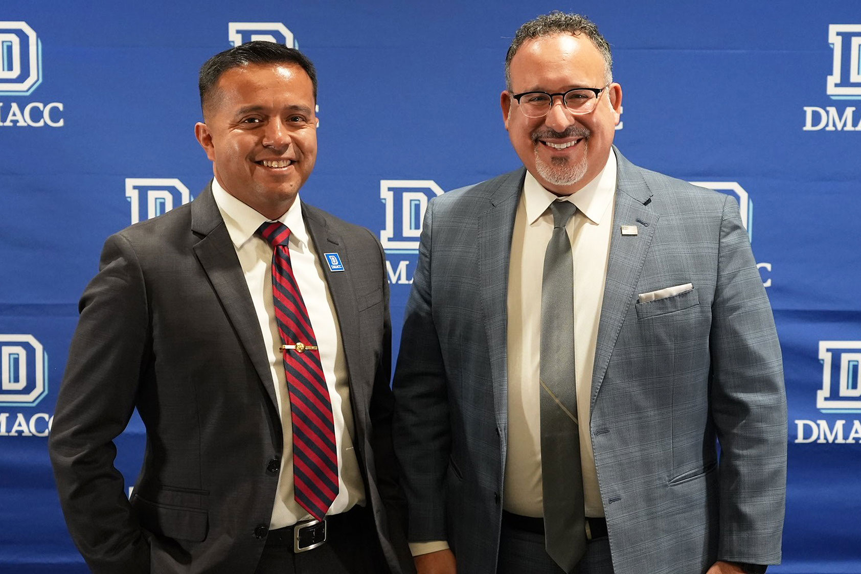DMACC Perry VanKirk Center Director Eddie Diaz (left) joins U.S. Secretary of Education Dr. Miguel Cardona​ for a photo during Cardona's Dec. 7, 2023, visit to Iowa.