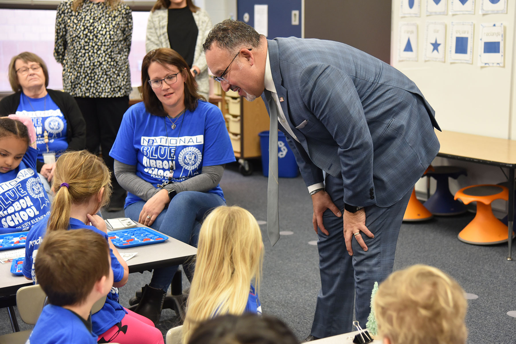U.S. Secretary of Education Dr. Miguel Cardona​ meets pre-school students while visiting a classroom at Perry Elementary School on Dec. 7, 2023, during his visit to Iowa. Seated next to Cardona is Felicia Moe, ​who began working as a paraeducator at Perry Elementary in 2018 through the Teacher Paraprofessional Registered Apprenticeship Program in collaboration with DMACC and UNI.